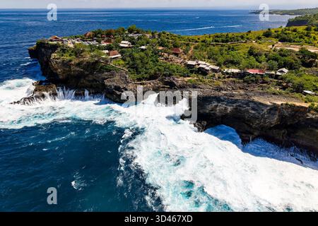 Surf puissant et mousse d'eau vive sur la côte volcanique accidentée de Nusa Penida Banque D'Images