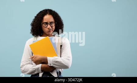 Etudiante noire frustrée se sentant stressée avec des ordinateurs portables sur fond bleu Banque D'Images