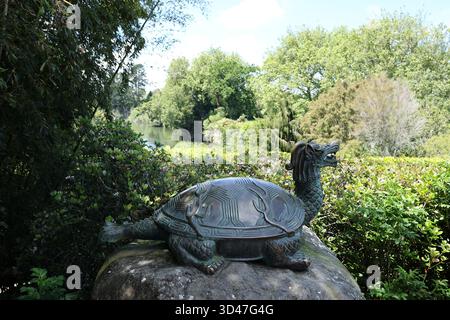 Statue de tortue dragon dans le jardin verdoyant au bord de la rivière Banque D'Images