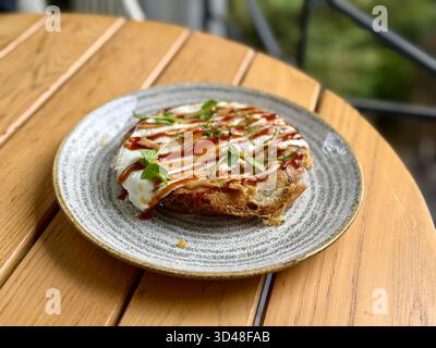 Hiroshima style okonomiyaki avec des œufs au plat pour le petit déjeuner aussi de la nourriture de rue Banque D'Images