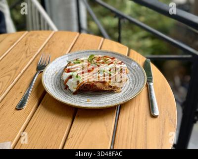 Hiroshima style okonomiyaki avec des œufs au plat pour le petit déjeuner aussi de la nourriture de rue Banque D'Images