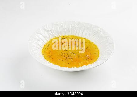 Soupe à la crème de citrouille isolée dans une assiette blanche Banque D'Images