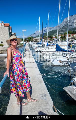 Femme touriste vacancier visitant la promenade autour du port dans la ville croate de Makarska Croatie Banque D'Images