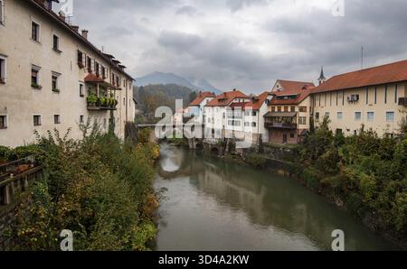 Vieille ville de Skofja loka reflétant sur la rivière Sorska avec un pont en pierre et des maisons colorées sous un ciel nuageux. Slovénie Europe Banque D'Images