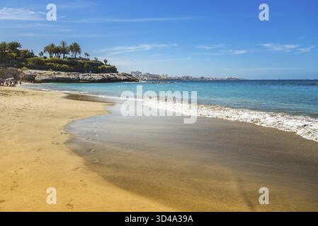 Les vagues douces de Playa Del Duque à Tenerife reflètent des nuances de turquoise et de bleu lorsqu’elles se touchent au rivage sablonneux. Cette plage sereine offre un Banque D'Images