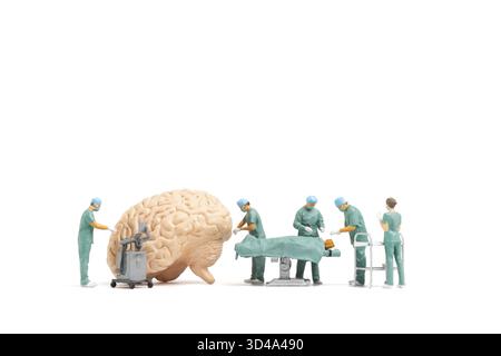 Les personnes miniatures, le médecin et l'équipe médicale d'infirmière effectuent une opération chirurgicale à la salle d'urgence sur fond blanc Banque D'Images
