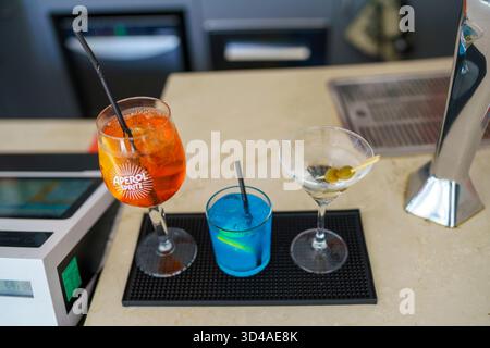 Crema, Italie - 25 août 2025 trois cocktails rafraîchissants disposés sur un comptoir de bar prêt à être servi lors d'une soirée tropicale Banque D'Images