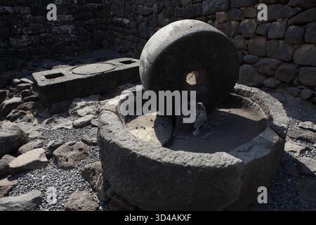 Ancienne roche basaltique huile d'olive presser, les olives ont été mises sur la pierre ronde inférieure pour être écrasées par la pierre supérieure tournée par un âne pour presser l'huile. Banque D'Images
