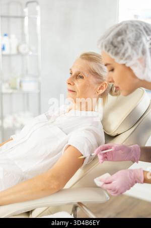 Patiente âgée sous injection intramusculaire au cabinet médical Banque D'Images