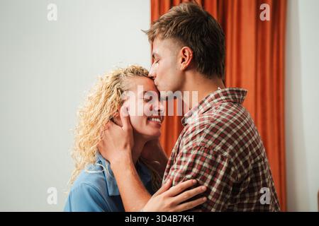 Une démonstration sincère de l'amour comme un couple aime un baiser tendre, embrassant l'autre avec joie et connexion, créant un beau moment rempli de Banque D'Images