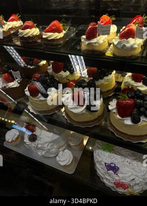 Assortiment de pâtisseries aux fruits et de gâteaux dans une vitrine de boulangerie Banque D'Images