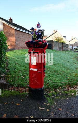 10 novembre 2025 hommage tricoté honorant les héros militaires sur une boîte postale rouge, Lichfield, Angleterre Banque D'Images