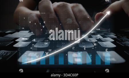 Une image en gros plan de mains tapant sur un clavier avec des graphiques financiers numériques et une superposition de données, montrant l'intersection de la technologie et de la finance Banque D'Images