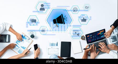 Une réunion d'affaires moderne mettant en vedette divers membres de l'équipe analysant les visuels de données sur les appareils numériques, en se concentrant sur des stratégies marketing innovantes et Banque D'Images