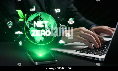 Une photo en gros plan de mains tapant sur un ordinateur portable, représentant un globe numérique qui représente zéro émission nette, mettant en évidence la durabilité et Banque D'Images