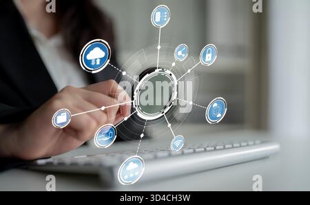 Une femme d'affaires s'engage avec des icônes numériques sur un ordinateur portable, illustrant la fusion de la technologie et de la communication dans un espace de travail moderne axé sur Banque D'Images
