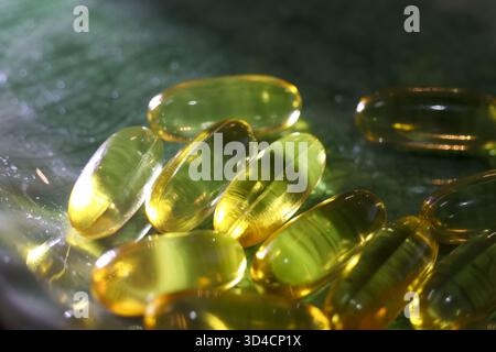 Capsules de supplément oméga jaunes saines contenant de l'huile de poisson. gros plan sur la nutrition vitaminique pour la santé et la médecine. Bénéfique pour les soins du corps et Banque D'Images