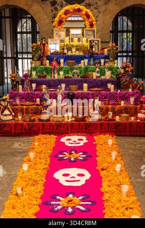 Un autel coloré avec des bougies et des crânes sur un tapis. L'autel est décoré pour une célébration. Fête mexicaine des morts tradition, offrandes, nourriture, co Banque D'Images