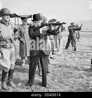 Le premier ministre Winston Churchill tire une mitrailleuse Thompson 'Tommy' aux côtés du commandant suprême allié du corps expéditionnaire allié, le général Dwight d Eisenhower, alors que les soldats américains regardent dans le sud de l'Angleterre à la fin de mars 1944. Winston Churchill tire une mitrailleuse Thompson aux côtés du commandant suprême allié, le général Dwight d Eisenhower, lors d'une inspection des forces d'invasion américaines, en mars 1944. Banque D'Images