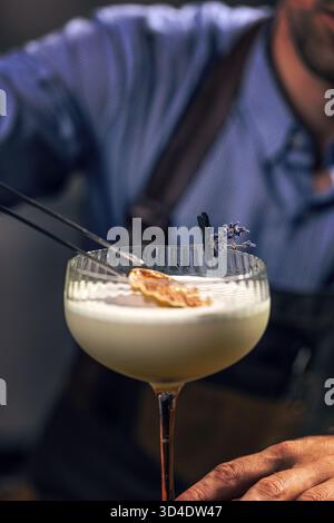 Cocktail de garniture de barman avec orange séchée et lavande Banque D'Images
