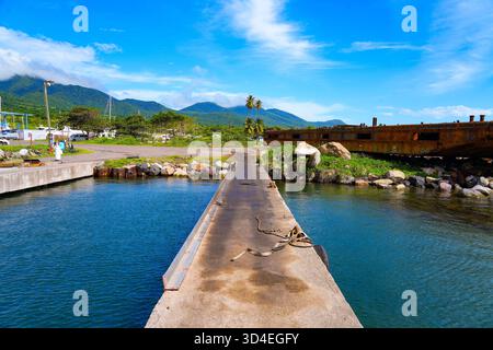 Barge rouillée sur un brise-lames de la ville de Nouvelle-Guinée sur la côte ouest de l'île de nouveaux Kitts dans la mer des Caraïbes Banque D'Images