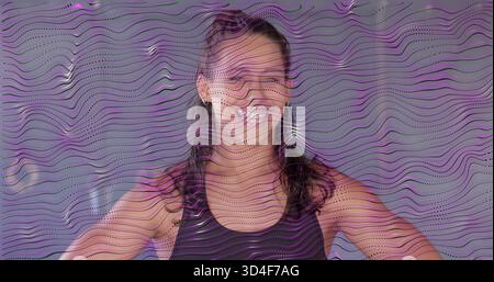 Femme hispanique debout souriante posant les mains sur les hanches en studio, dans le réservoir noir goujons ondulés superposition Banque D'Images