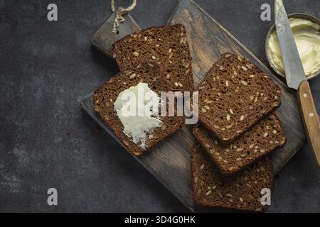 Nourriture, pain de seigle foncé fait maison avec des graines de tournesol, fond sombre, vue de dessus Banque D'Images