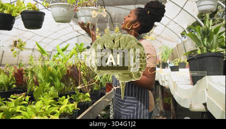 Inspectant une femme portant un tablier rayé vérifiant la jardinière blanche suspendue au banc de la pépinière, superposition ai Banque D'Images