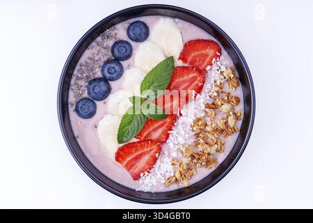 Nourriture, pudding au yaourt avec banane, fraises, graines de chia et granola sur fond blanc Banque D'Images