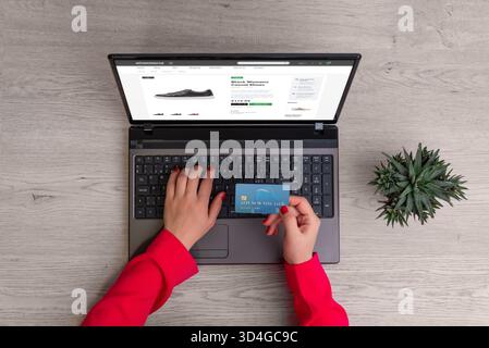 Femme magasinant en ligne pour des chaussures en utilisant la carte de crédit et l'ordinateur portable, paiement sécurisé et concept de vente au détail e-commerce moderne Banque D'Images