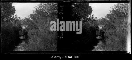 Cette image, prise entre 1899 et 1910 par Josep Maria Armengol i Bas, montre un ruisseau coulant sous un pont entouré de végétation, soulignant la beauté naturelle et la tranquillité de la région. Banque D'Images
