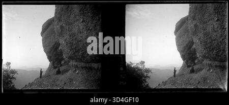 Cette image montre deux personnes à côté du massif de Sant Llorenç del Munt, capturé par Josep Maria Armengol i Bas entre 1899 et 1910. Il met en valeur le terrain montagneux et l'interaction humaine avec le paysage. Banque D'Images