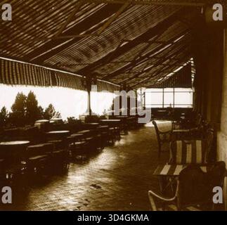 Photographie de Santiago Perdigó i Díaz Caneja de 1923, montrant des chaises sous un auvent sur la terrasse du Gran Hotel de font-Romeu. L'image illustre la disposition des sièges extérieurs, typique de la terrasse de l'hôtel dans un cadre de station de montagne. Banque D'Images