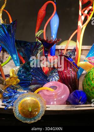 SEATTLE - 25 avril 2025 - fleurs vibrantes en verre soufflé à la main qui poussent à partir d'un bateau en bois altéré, représentant l'artisanat artistique et la création botanique Banque D'Images