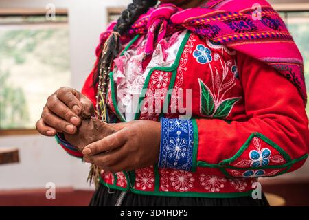 Gros plan d'une femme quechua façonnant l'argile pendant une séance de poterie traditionnelle. Pisac, région de Cusco, Pérou, 2025-05-29. Banque D'Images