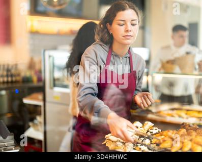 Fille vendeuse travaille dans la boutique de boulangerie cafétéria Banque D'Images