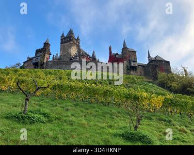Le château de Reichsburg Cochem domine de façon spectaculaire des vignes verdoyantes sur une colline ensoleillée à Cochem, en Rhénanie-Palatinat, en Allemagne. Banque D'Images
