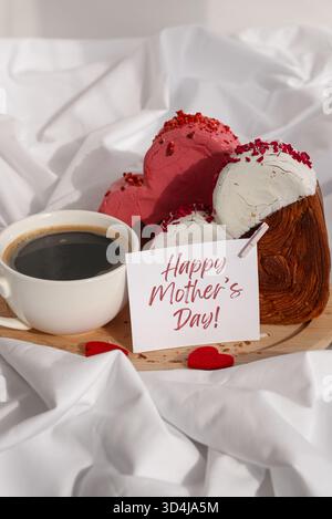 JOYEUSE FÊTE DES MÈRES message papier carte de note du matin petit déjeuner célébration délicieux croissants frais de variété garni de saveur colorée Ganache. Création unique boulangerie en forme de coeur. Feuilleté de vacances amour cadeau idée de cadeau cadeau. Copier l'espace Banque D'Images