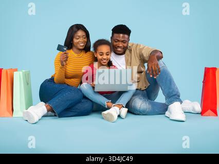 La famille aime magasiner en ligne ensemble pendant l'après-midi à la maison Banque D'Images