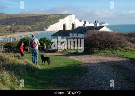 Les marcheurs voient les falaises des sept Sisters à Seaford Head sur le sentier South Downs National Park, East Sussex, Royaume-Uni Banque D'Images