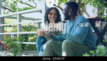 Assis couple sirotant des tasses en céramique sur les marches du porche par balustrade blanche, avec montre, plantes, superpositions Banque D'Images