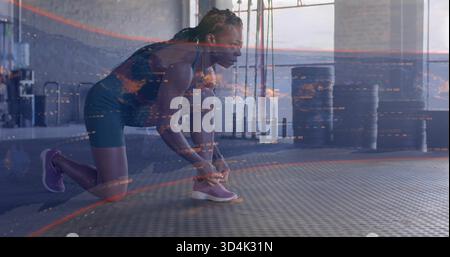 Femme agenouillée dans l'équipement athlétique sombre nouant chaussure de course violette sur tapis de gymnastique en caoutchouc, superposition numérique Banque D'Images