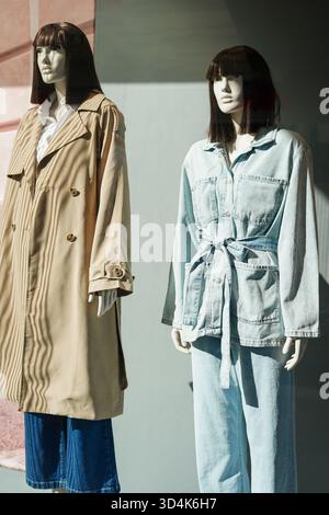 Deux mannequins féminins vêtus d'un trench décontracté et d'une tenue en denim en vitrine Banque D'Images