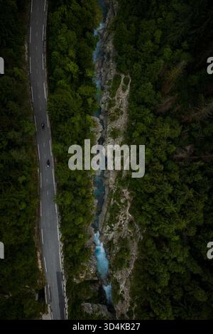 La vue aérienne sur la rivière Soca turquoise se fraie un chemin à travers une gorge verdoyante le long d'une route sinueuse, un mélange époustouflant d'art et de bourdonnement de la nature Banque D'Images