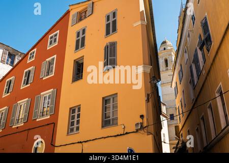 Une des tours de l'église Saint-Jean-Baptiste vue à travers une rue étroite avec des bâtiments colorés dans la vieille ville, Bastia, Corse, France Banque D'Images