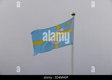 Le drapeau de l'île de Skye volant sur un mât de drapeau sous un ciel couvert, Écosse, Royaume-Uni. Banque D'Images
