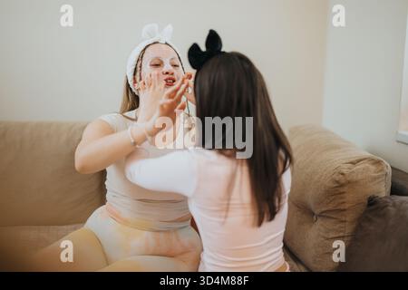 Deux filles faisant des soins de la peau à la maison ensemble dans un environnement relaxant Banque D'Images
