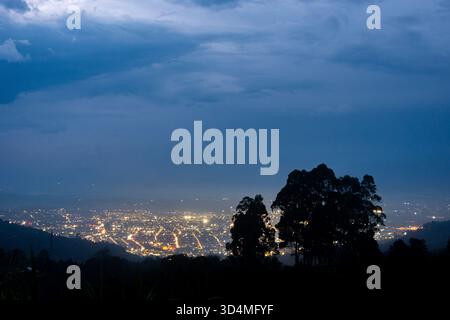 Une vue nocturne époustouflante de Popayán, Cauca, Colombie, mettant en valeur les lumières de la ville sous un ciel nuageux spectaculaire. Banque D'Images