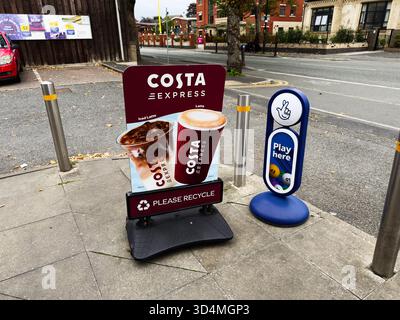 Manchester, Royaume-Uni - 30 septembre 2025 : stand publicitaire pour Costa Express Coffee dans une rue de Manchester, à côté d'un panneau bleu jouer ici. Banque D'Images