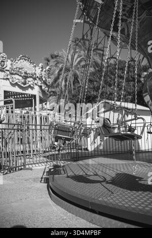Un carrousel vide tourne sans enfants. Personne ne monte sur le carrousel. Noir et blanc appuyant sur photo. Banque D'Images